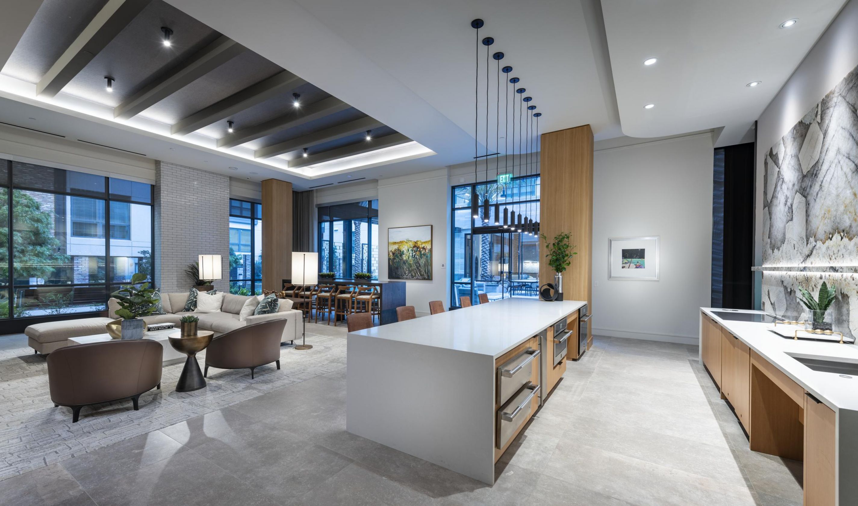 Modern open-concept kitchen and living room with sleek decor, large windows, and elegant lighting at Hanover Corporate Soma West.