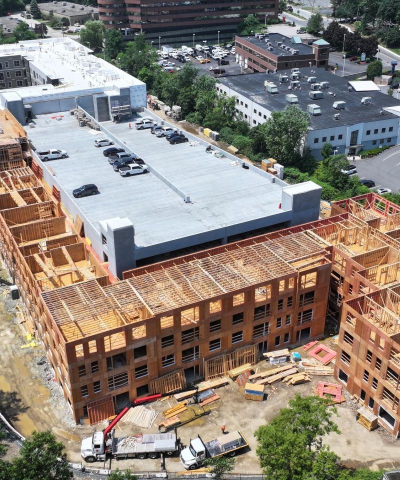 Hanover Company Aerial view of a large building under construction, surrounded by roads and trees.