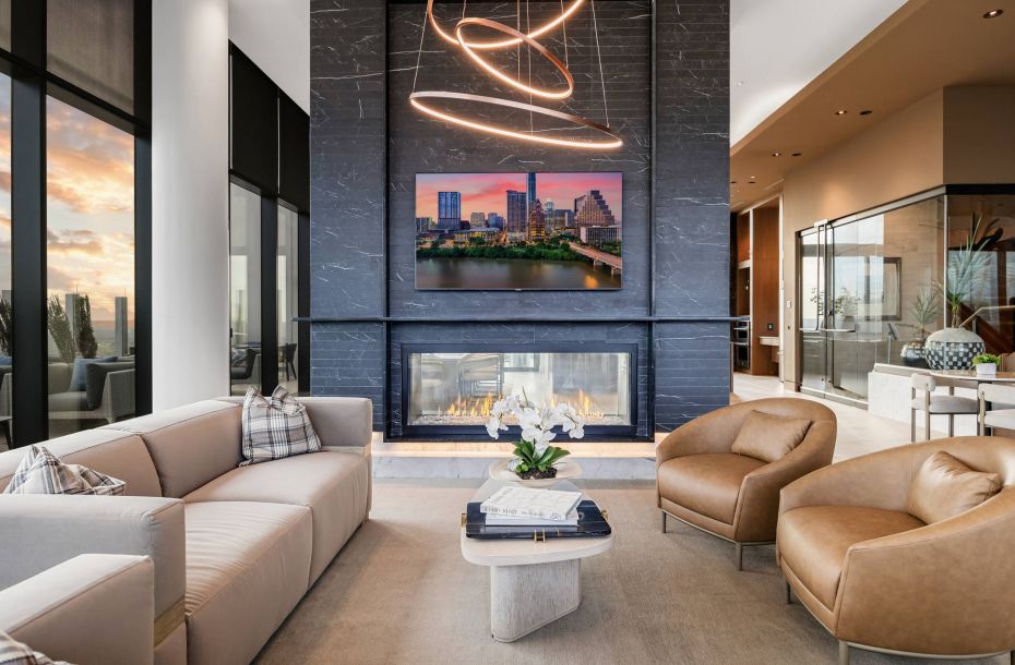 Hanover Company, Hanover Brazos Modern living room with large windows, sleek furniture, a double-sided fireplace, and futuristic ceiling lights.