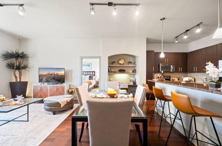Hanover Company, Hanover Rice Village Modern open-plan living and dining area with a kitchen, featuring sleek furniture, ambient lighting, and contemporary decor.