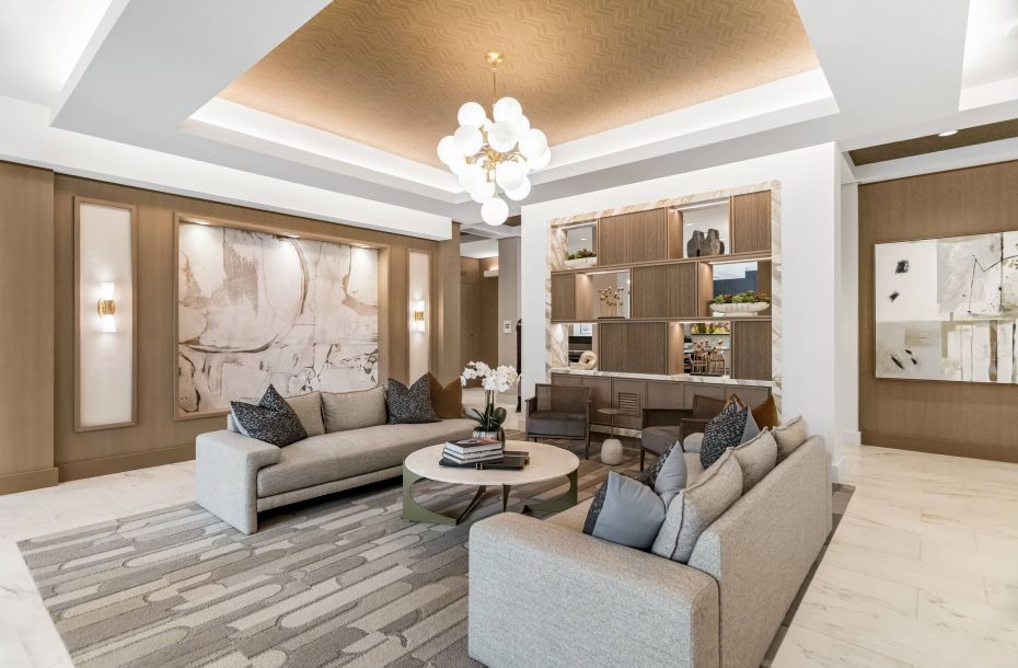 Hanover Company, Luxurious modern living room with a beige sofa, round coffee table, abstract art, and elegant chandelier.