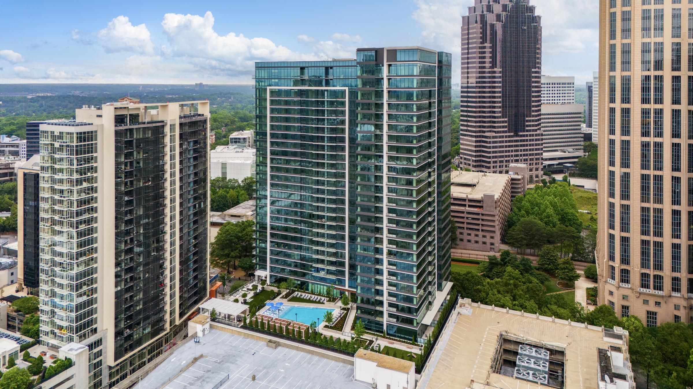 Aerial view of a cityscape with Hanover Company corporate modern high-rise buildings and a rooftop pool.