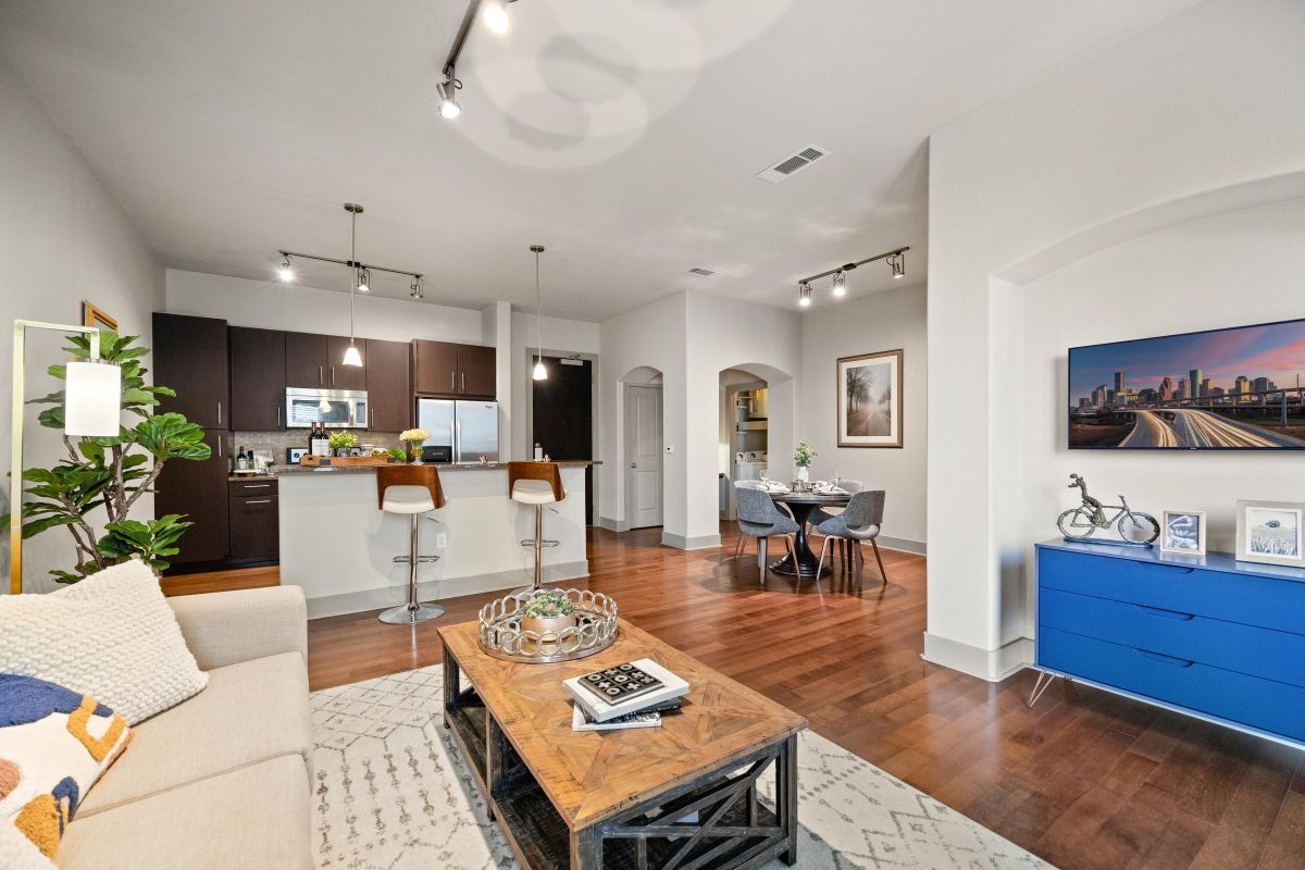 Hanover Company Modern open-concept living space with kitchen, dining area, and cozy seating, featuring hardwood floors and stylish decor.