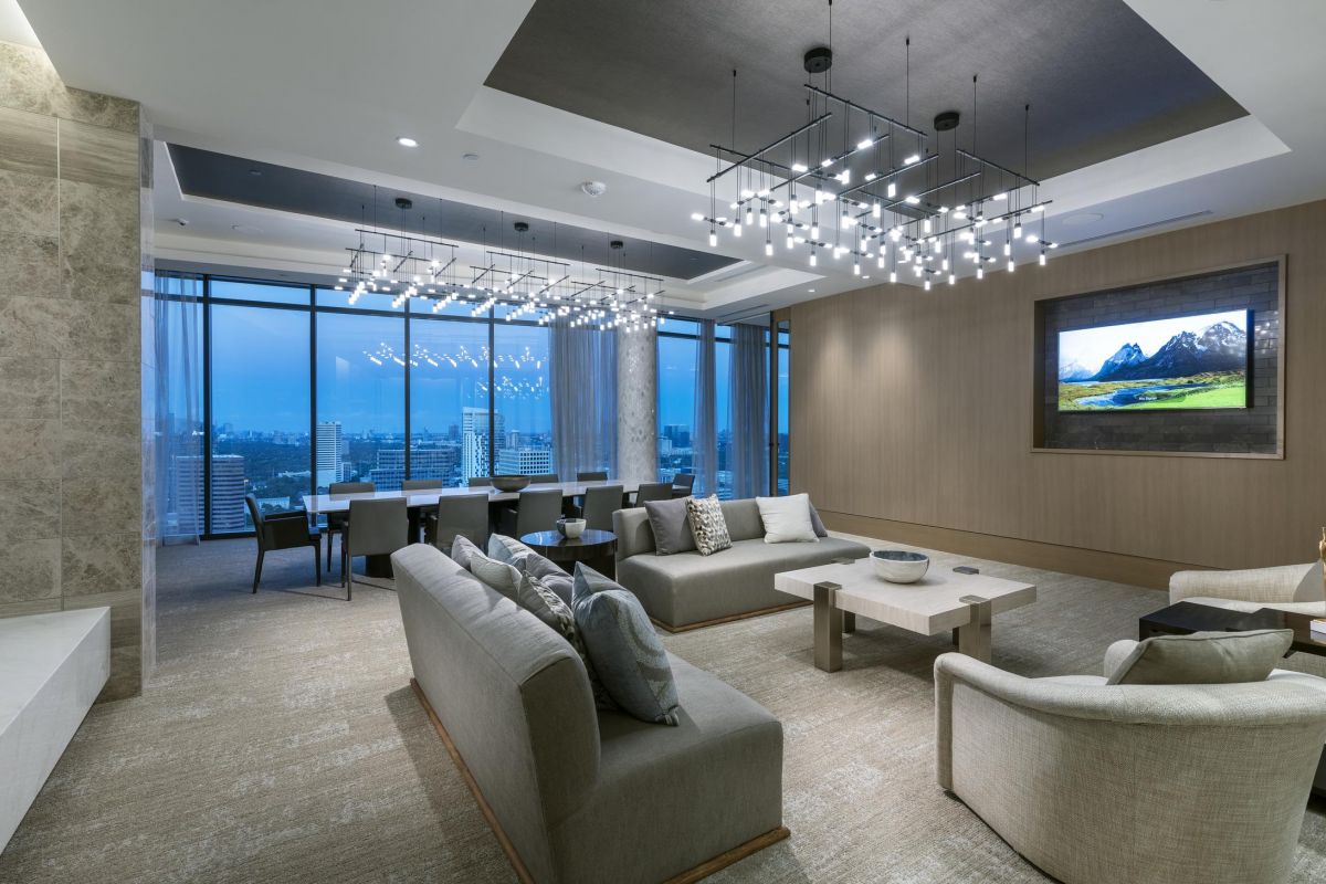 Modern living room with sofas, a dining table, and city view. Ceiling lights and a wall-mounted TV add elegance.