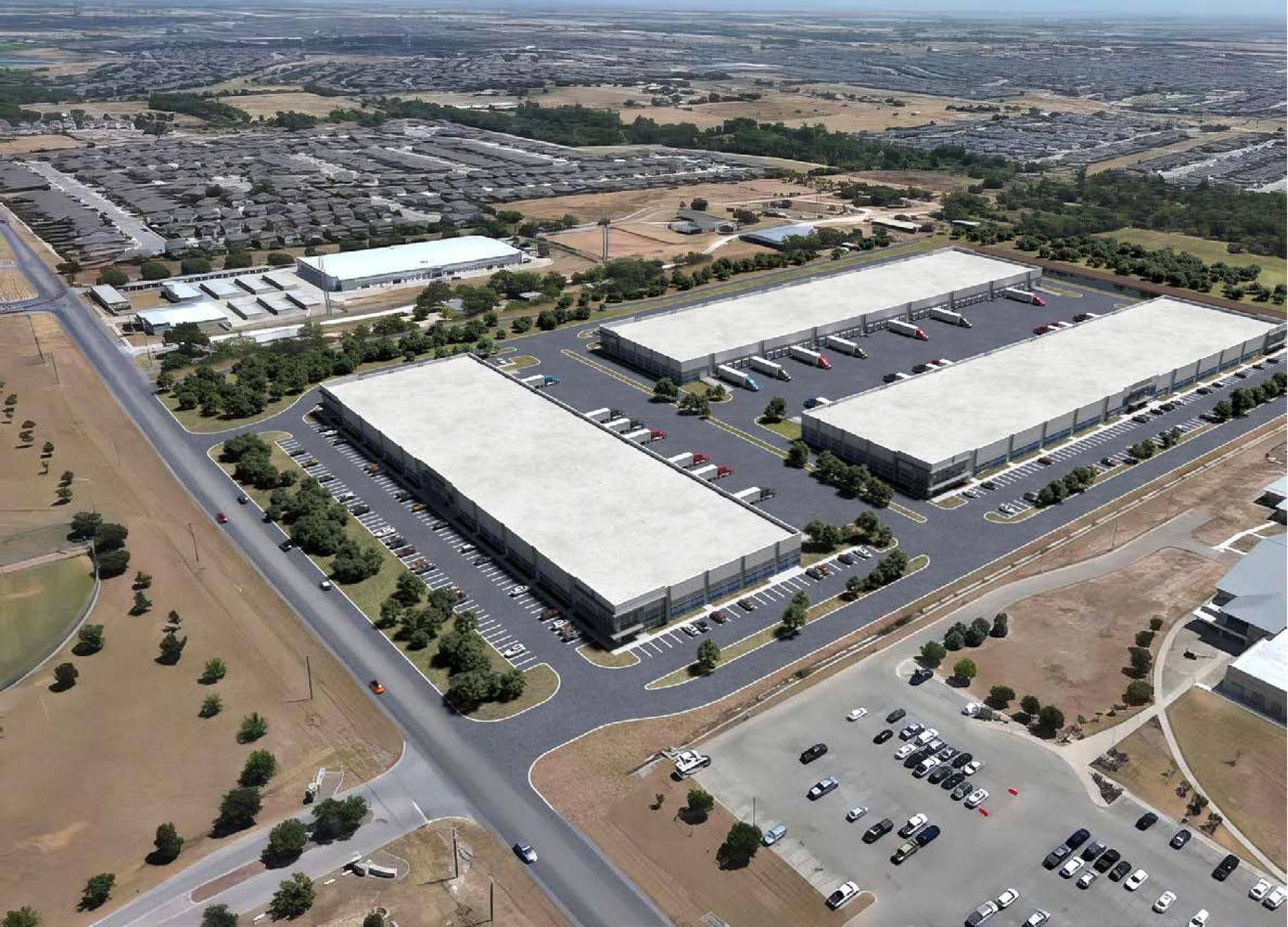 Hanover Company Aerial view of a large industrial complex with three rectangular warehouse buildings and numerous parked trucks.
